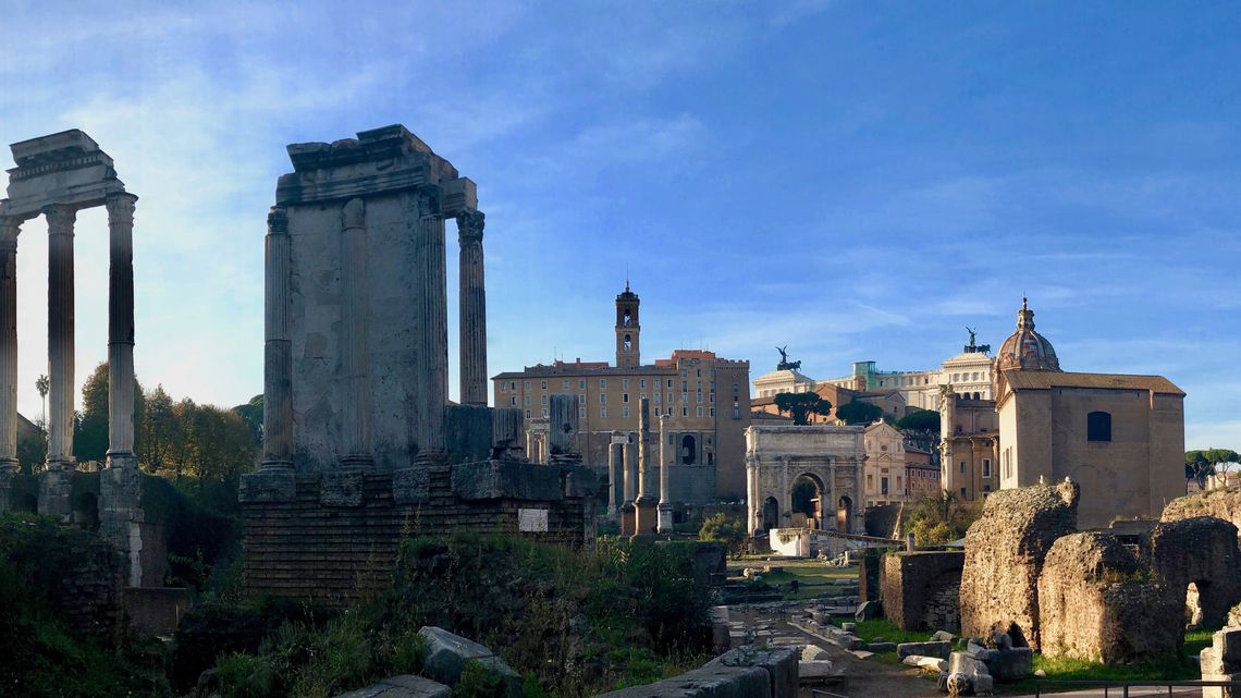 I Fori Romani nella luce del mattino: le colonne del tempio dei Dioscuri, i ruderi in primo piano e l'arco di Settimio Severo sullo sfondo