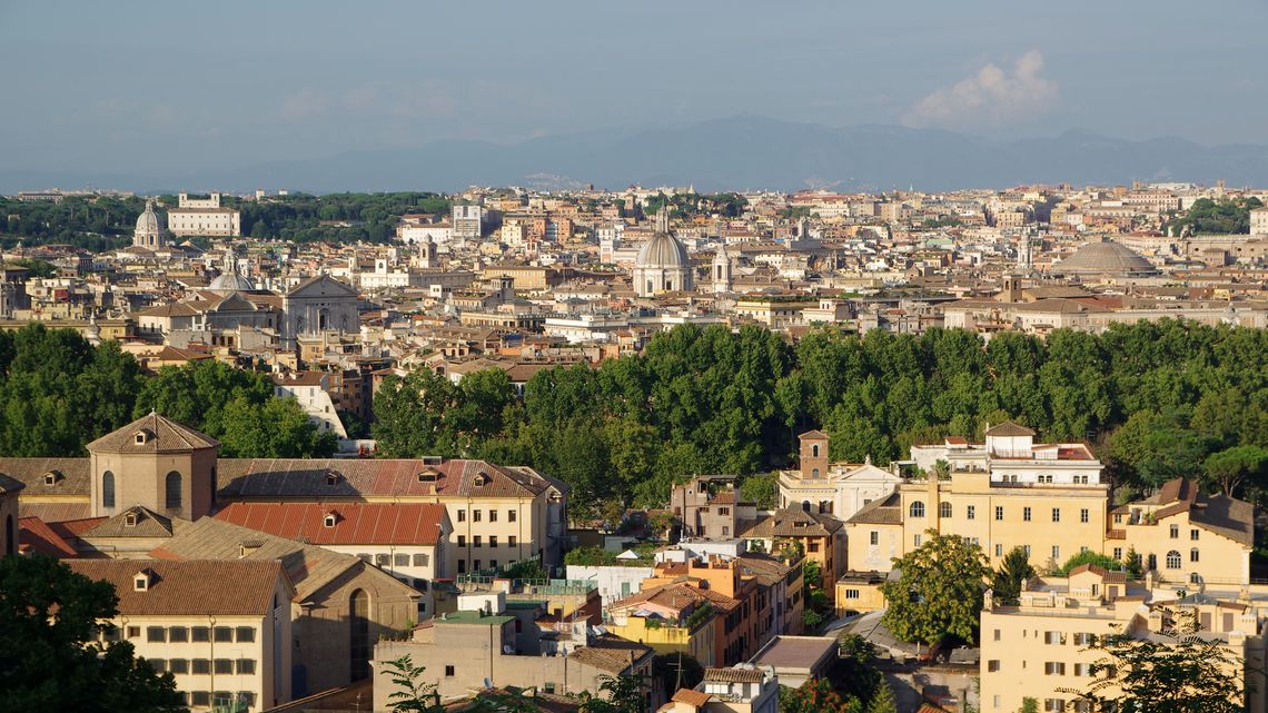 Roma vista dal Gianicolo: tetti e terrazze di Trastevere in primo piano, le cupole del centro dietro, i monti all’orizzonte