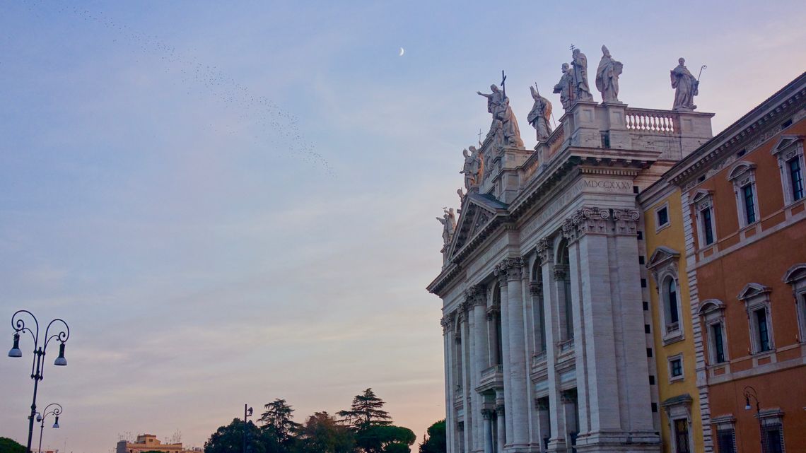La facciata di San Giovanni in Laterano al tramonto, con le statue in cima